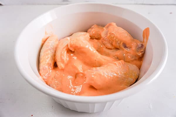 chicken wings and sauce in a white dish