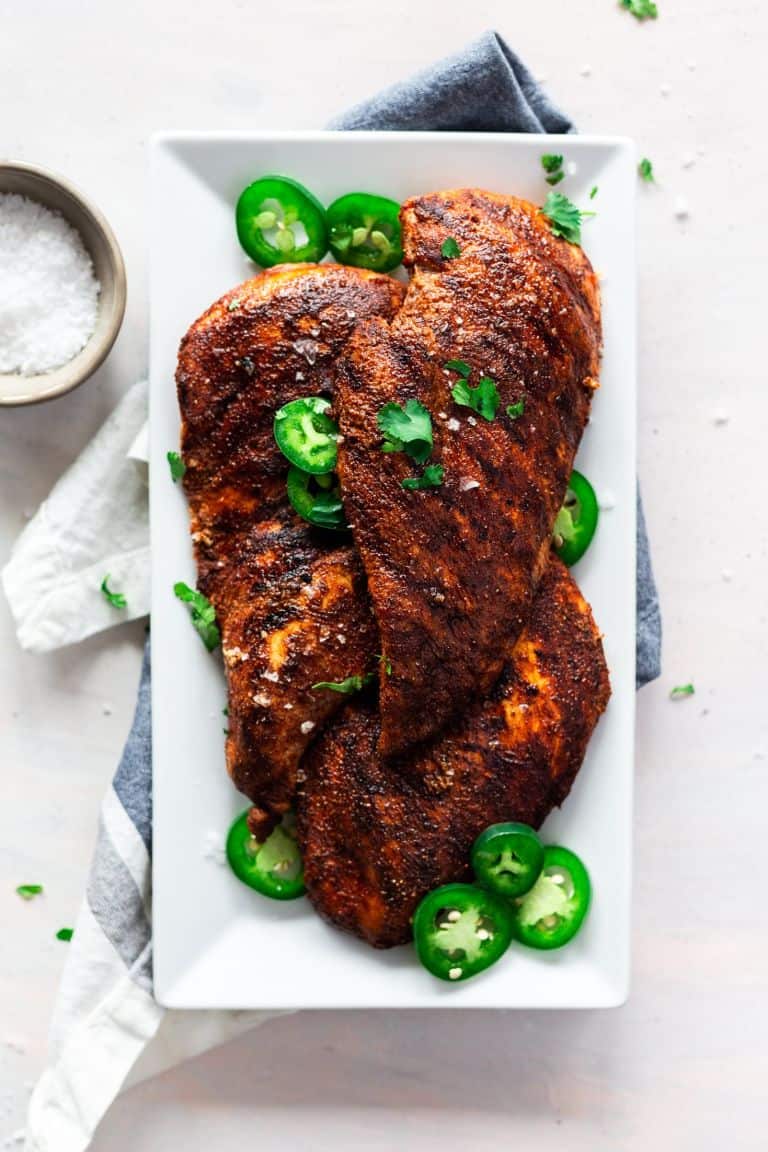 grilled harissa chicken on a white tray on a white background