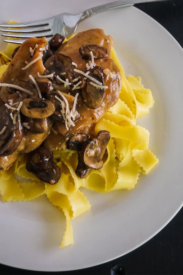 Slow Cooker Chicken Marsala next to a fork on a white plate