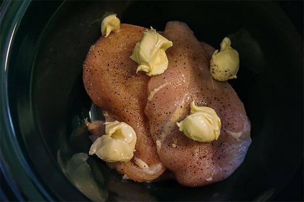 raw chicken, olive oil, butter and seasoning in a slow cooker