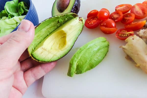 slice your cherry tomatoes in half and slice your avocado into strips