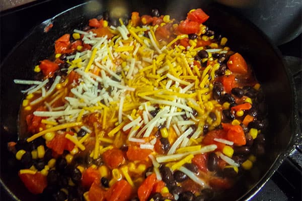 shredded cheese on top of Santa Fe chicken in a skillet