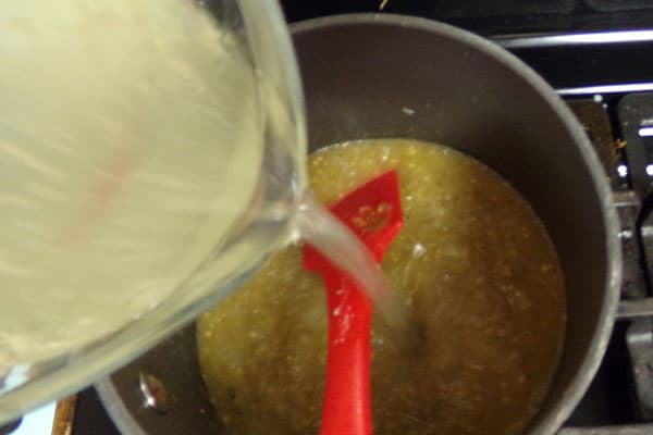 chicken broth being poured into a pot