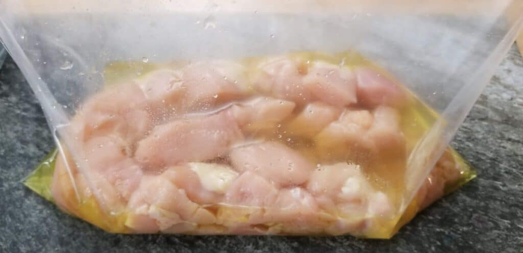 cubed chicken in pickle juice inside the plastic bag.