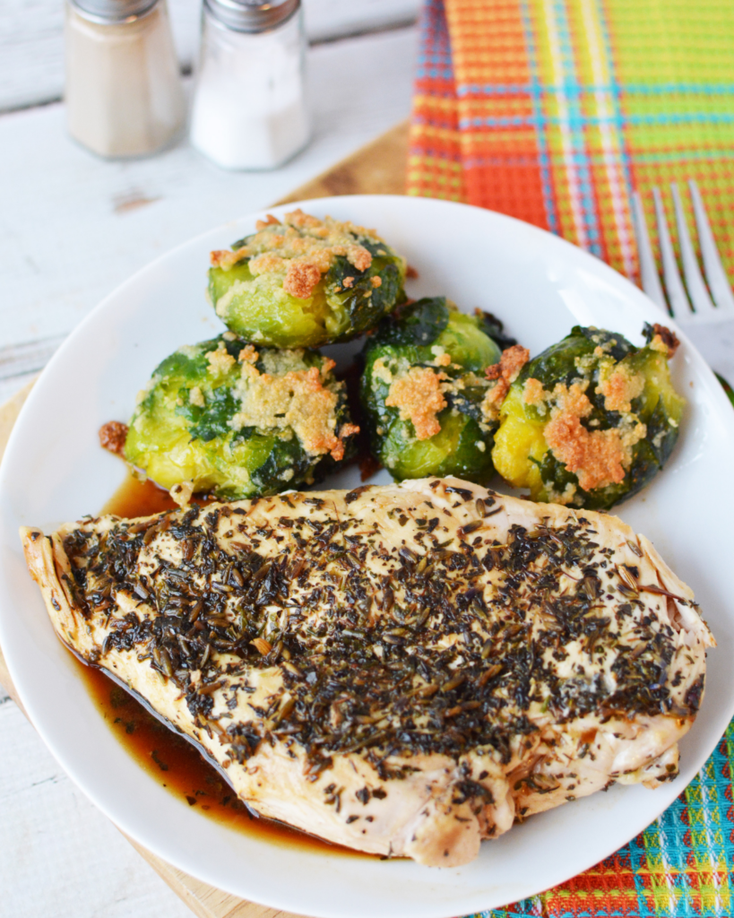 Herbed Chicken Breasts on a plate with brussel sprouts on the side.