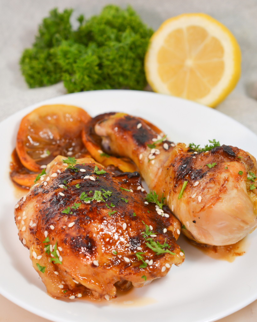Sticky Honey Soy Chicken on a plate sprinkled with sesame seeds and chopped parsley. 