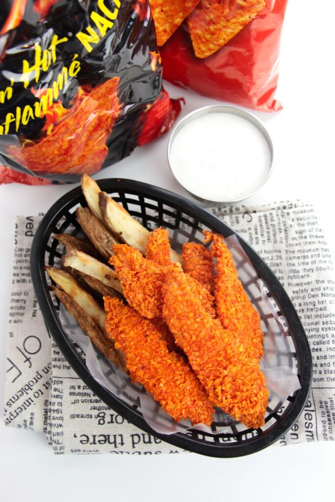 doritos chicken fingers and fries in a basket next to dipping sauce.