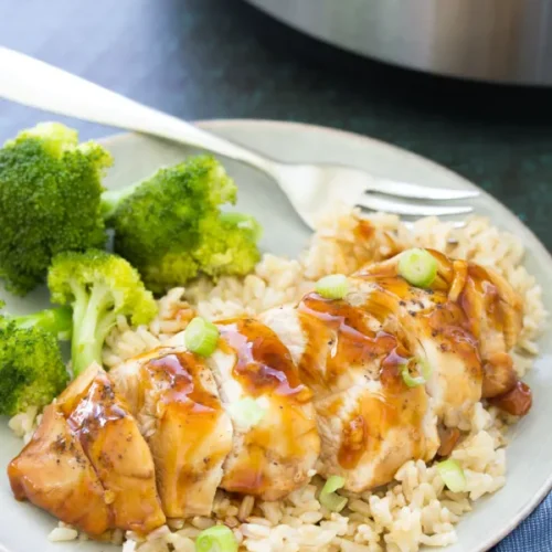Chicken served on top of rice alongside broccoli