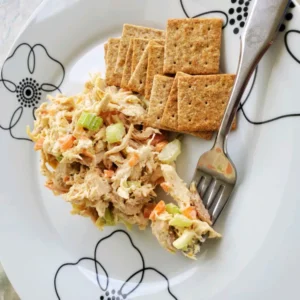 fork in chicken salad alongside crackers